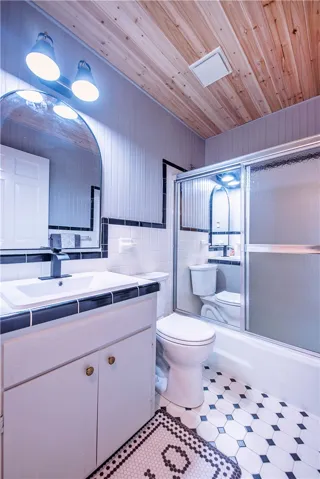 A natural wood paneled ceiling complements the classic black and white tile flooring.