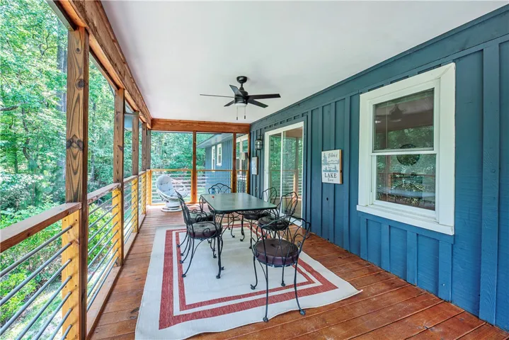 A screened porch overlooks peaceful wooded views through floor-to-ceiling panels.