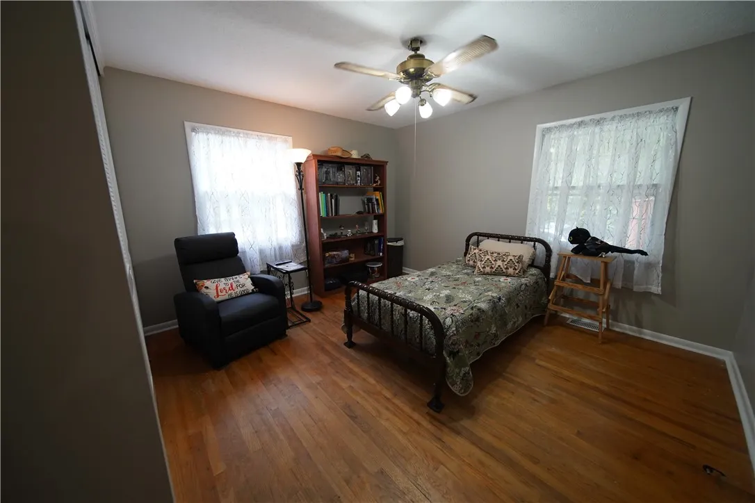 Gleaming hardwood floors run throughout this comfortable bedroom boasting multiple large windows.