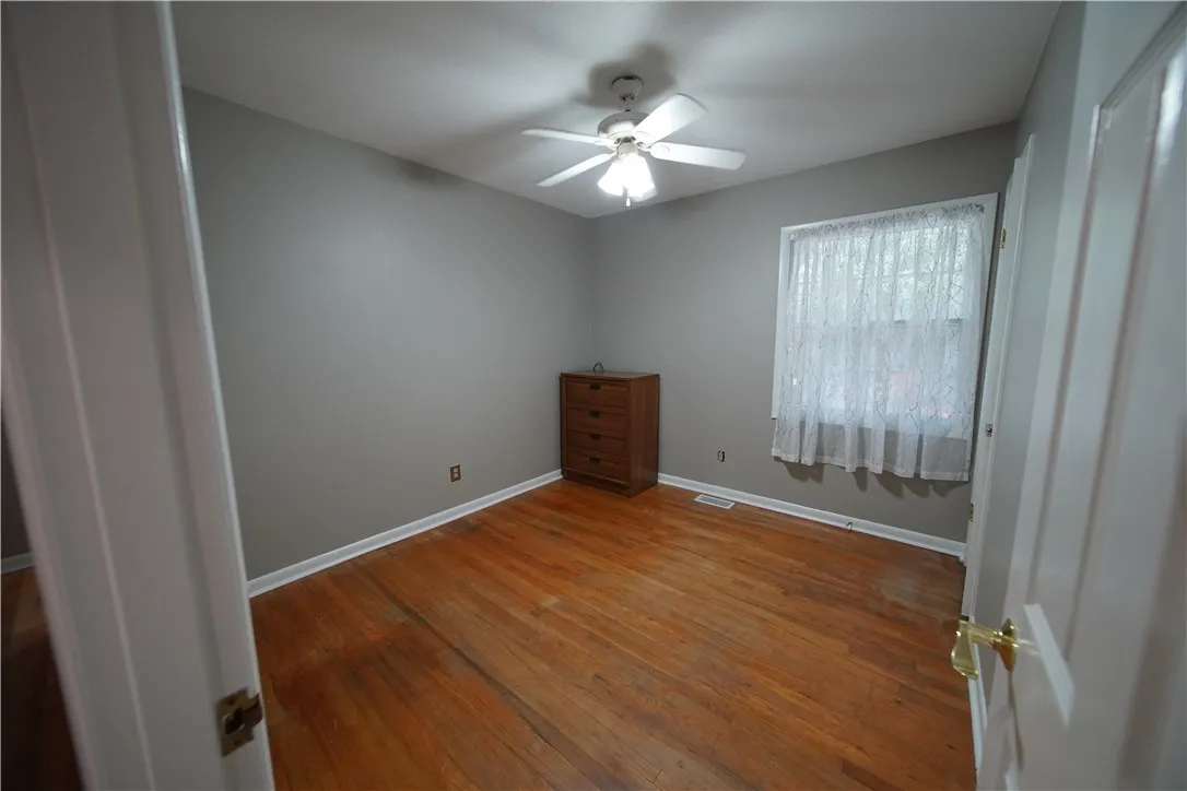Warm hardwood flooring and classic white trim define this versatile room with natural light.