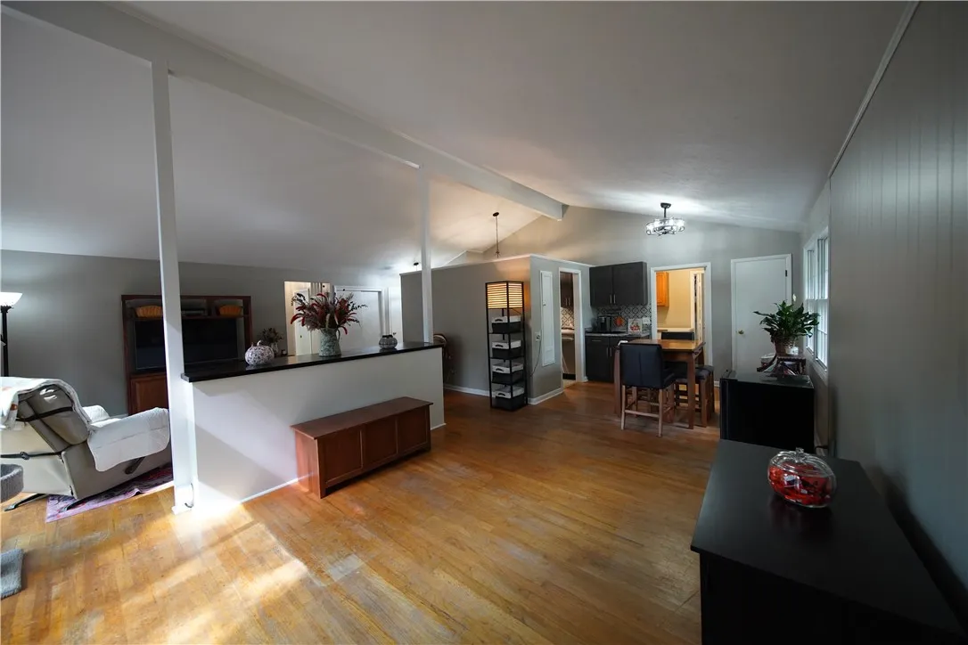 Gleaming hardwood floors and vaulted ceilings define this inviting, open-concept living area.