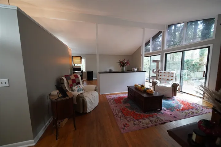 Soaring vaulted ceilings and sliding glass doors maximize natural light across the hardwood floor.