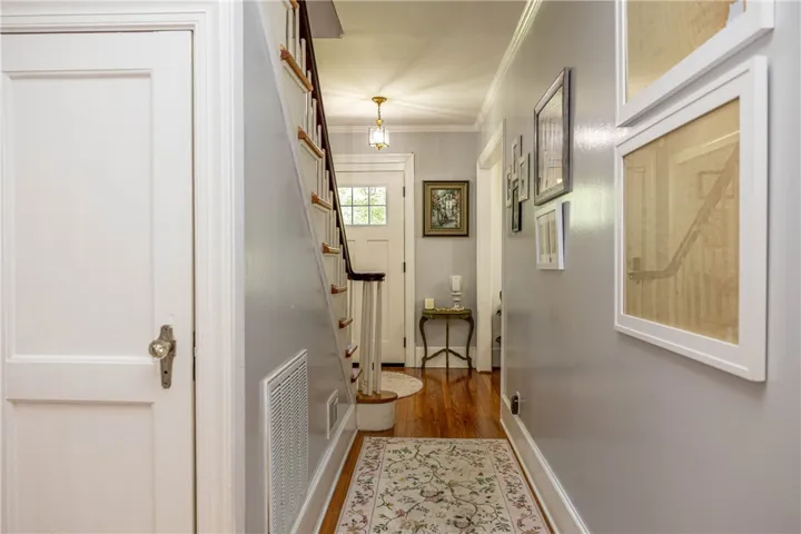 Rich hardwood flooring and crown molding define this inviting entry and hallway.