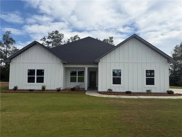 Crisp board and batten siding pairs beautifully with a dark shingle roof under wide skies.
