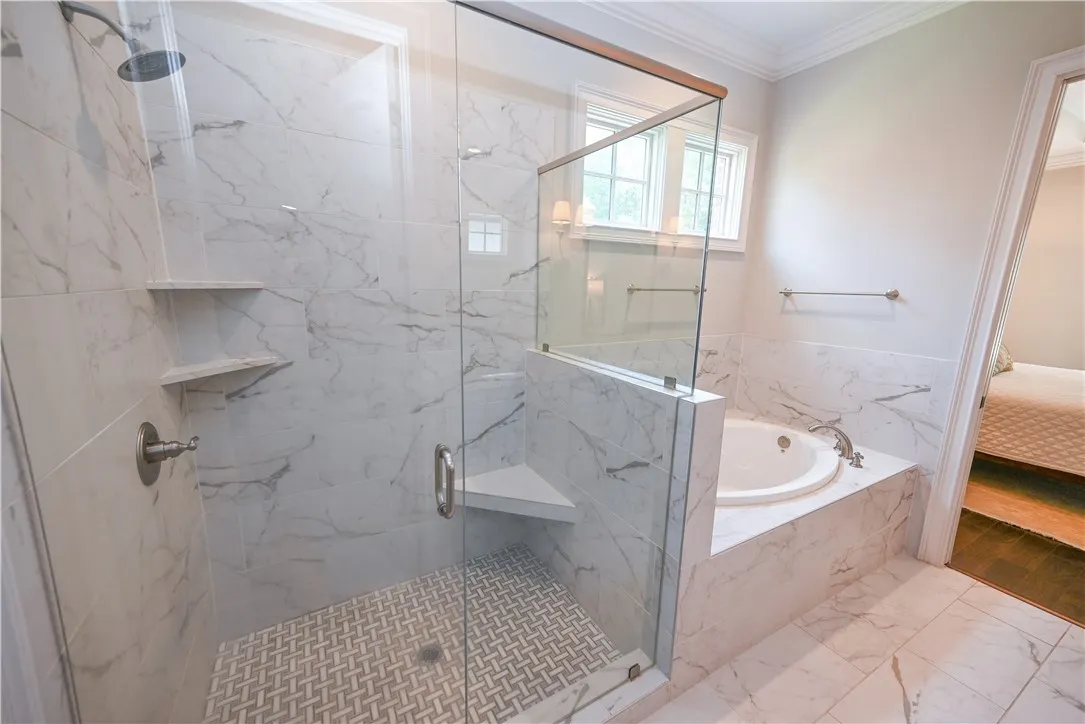 Large step-in shower with basket-weave tile floor detail.