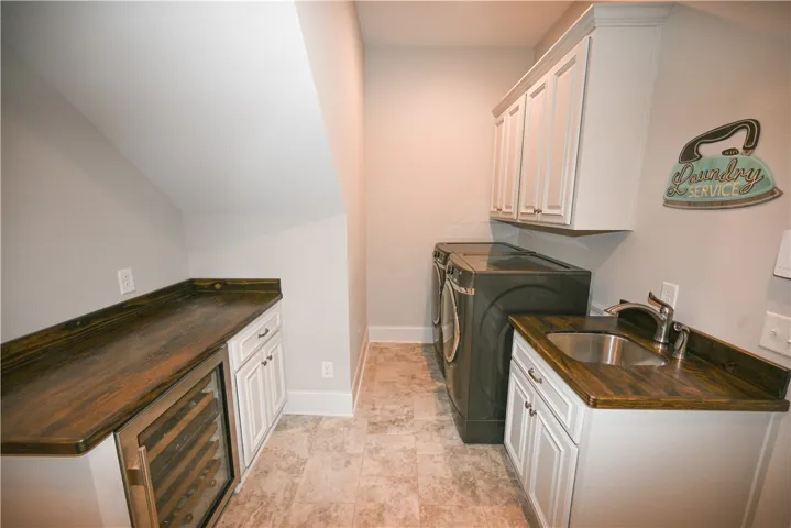 Laundry with tons of extra storage, sink, & beverage station!