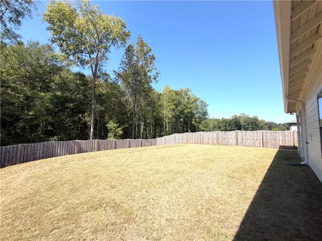 The fenced backyard  offers excellent privacy , surrounded by trees.