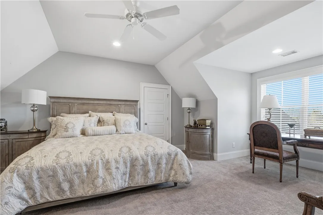 An expansive upstairs bedroom filled with natural light and ample space for both sleeping and a sitting or workspace area—ideal for guests or flexible use.