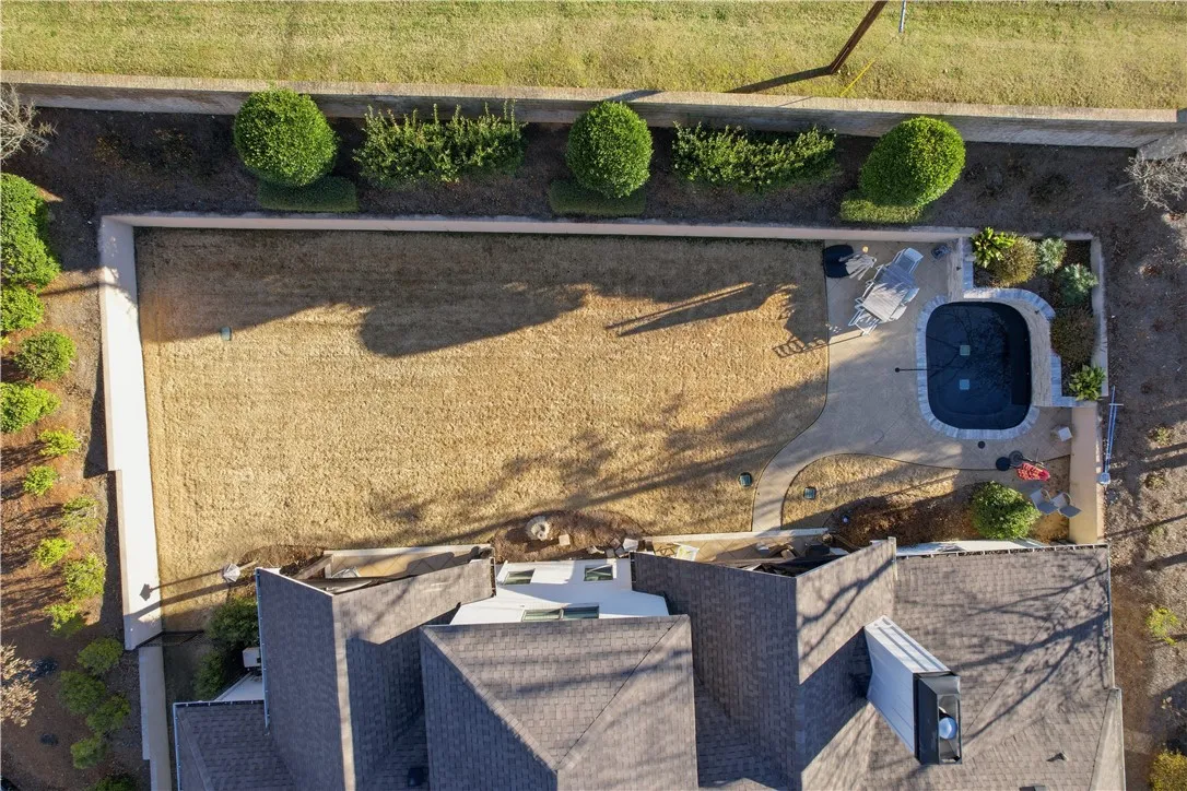 This aerial view showcases the yard’s privacy—created by walls, landscaping, and fencing—while also highlighting its size and the thoughtful placement of the pool.
