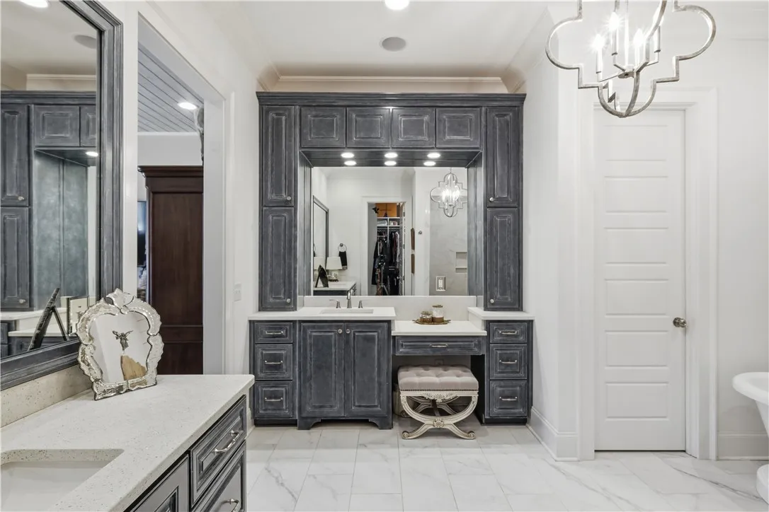Two generous vanities—one complete with a dressing table and linen towers—provide ample storage.