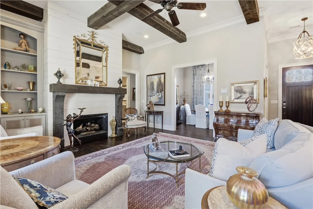 A substantial gas fireplace with a shiplap surround, paired with built-in cabinetry, anchors the great room.