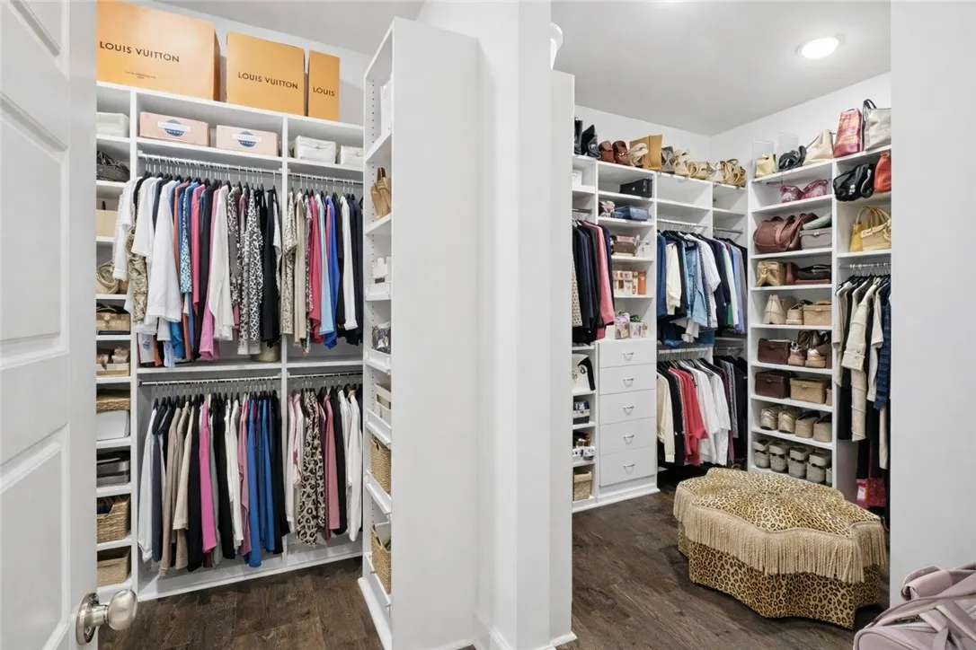 Expansive walk-in closet featuring custom shelving, abundant hanging space, built-in drawers, and dedicated storage for shoes and handbags.