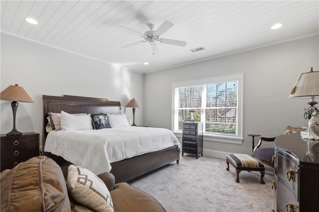 This second-floor bedroom overlooks the backyard and features a wood ceiling that adds character. A walk-in closet and en suite bath create a comfortable retreat.