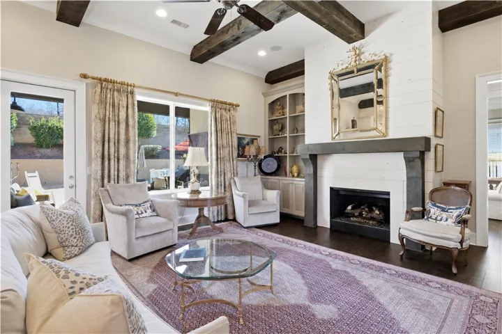 The living room’s large windows capture views of the backyard and pool.