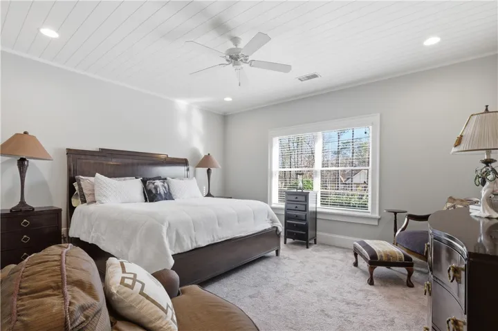 This second-floor bedroom overlooks the backyard and features a wood ceiling that adds character. A walk-in closet and en suite bath create a comfortable retreat.