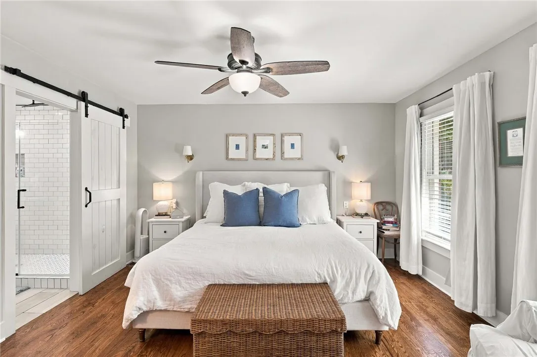 Gleaming hardwood floors and a sliding barn door elevate this comfortable bedroom suite.