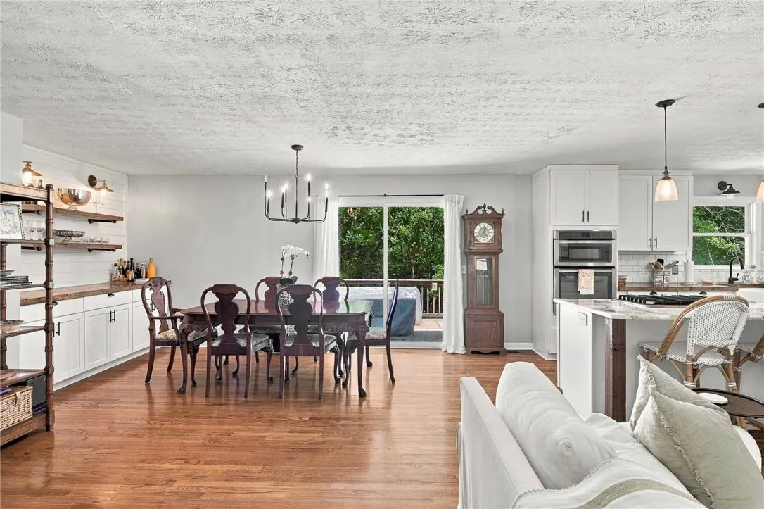 Rich hardwood floors anchor this open-concept layout connecting the dining space and kitchen.