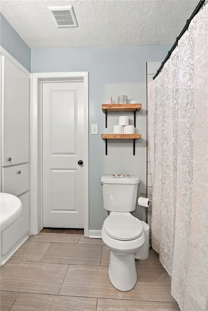 Tiled flooring and built-in storage cabinets define this practical bath space.