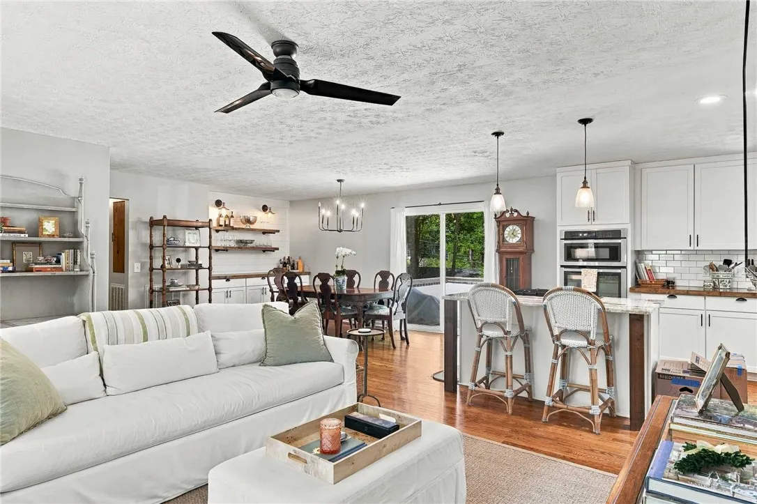 Gleaming hardwood floors run through this airy, open-concept living area and kitchen.