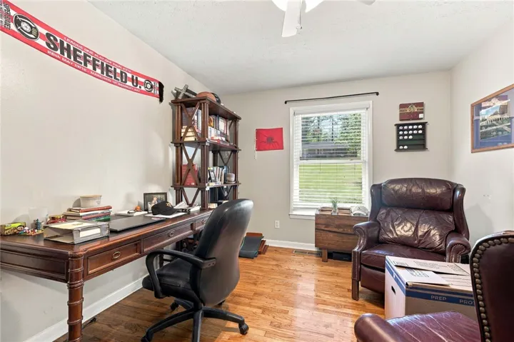 Gleaming hardwood floors and a bright window elevate this versatile study space.
