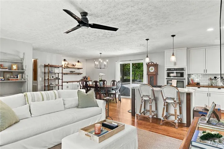 Gleaming hardwood floors run through this airy, open-concept living area and kitchen.