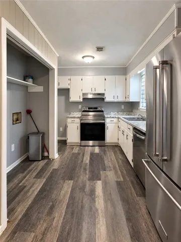 Gleaming wood-look flooring anchors this modern kitchen accented by sleek stainless steel appliances.
