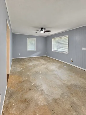 Wood-paneled walls and concrete subfloors await custom finishes in this versatile bonus space.