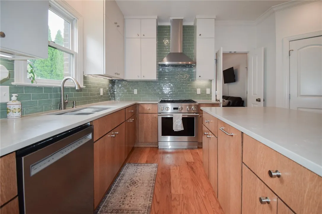 Rich wood floors meet pristine stone counters in this modern, highly functional kitchen space.