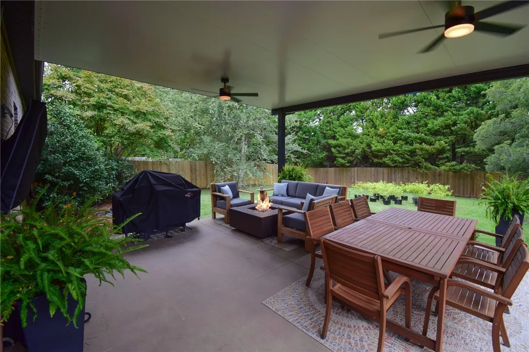 A spacious covered patio overlooks the fenced backyard complete with lush green lawns and mature trees.