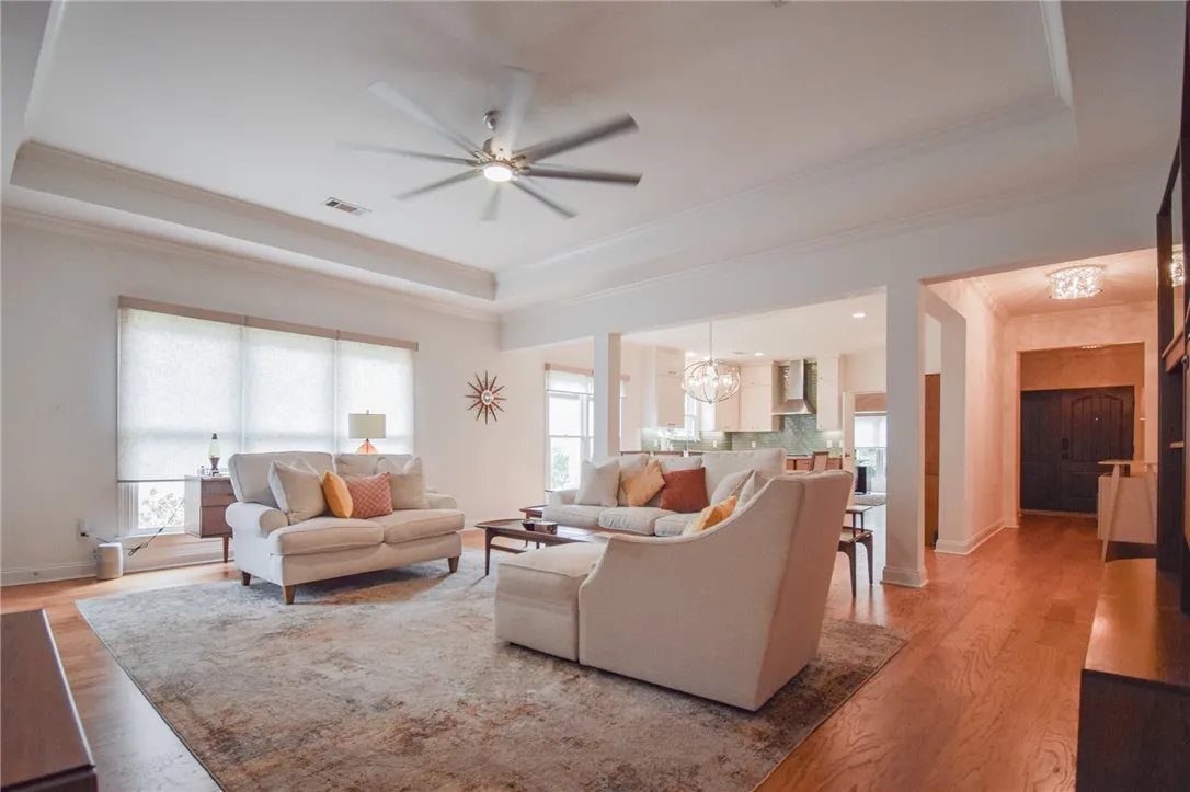 Rich hardwood flooring complements the deep tray ceiling in this open-concept main level.