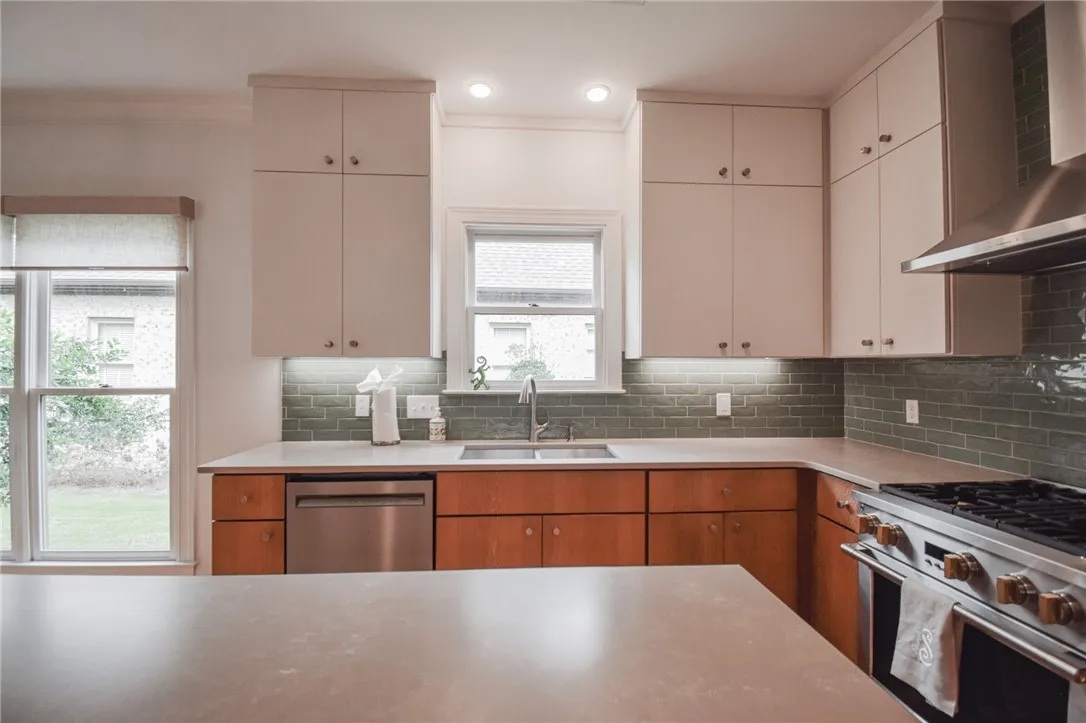 Streamlined cabinetry and classic tiled backsplashes anchor this thoughtfully designed cooking space.