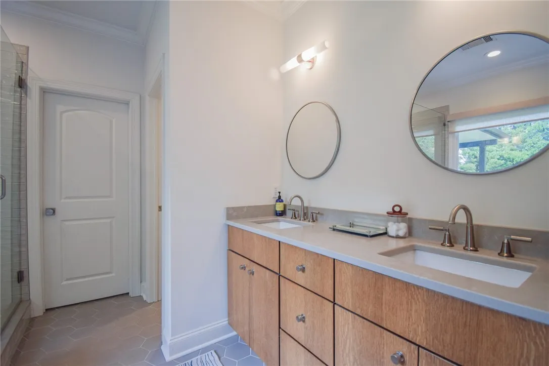 Geometric floor tile and a double vanity create a refined atmosphere in this bathroom.