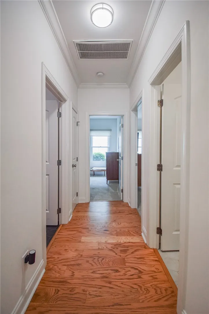 Gleaming hardwood floors guide you through a classic hallway accented by traditional crown molding.