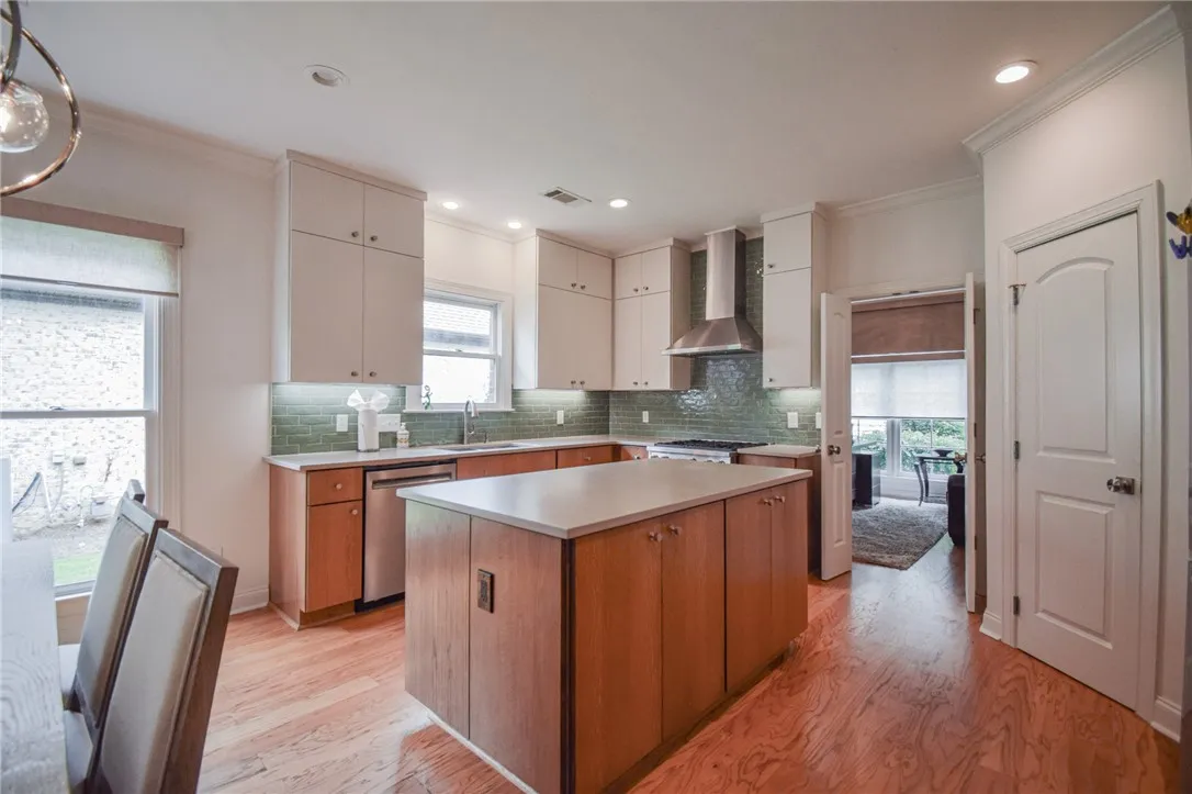 Gleaming hardwood floors and a spacious central island anchor this meticulously designed modern kitchen.