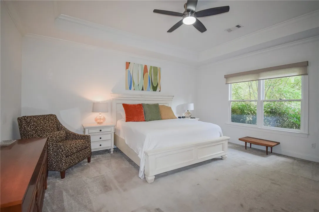 Plentiful natural light streams through wide windows under an elegant tray ceiling.