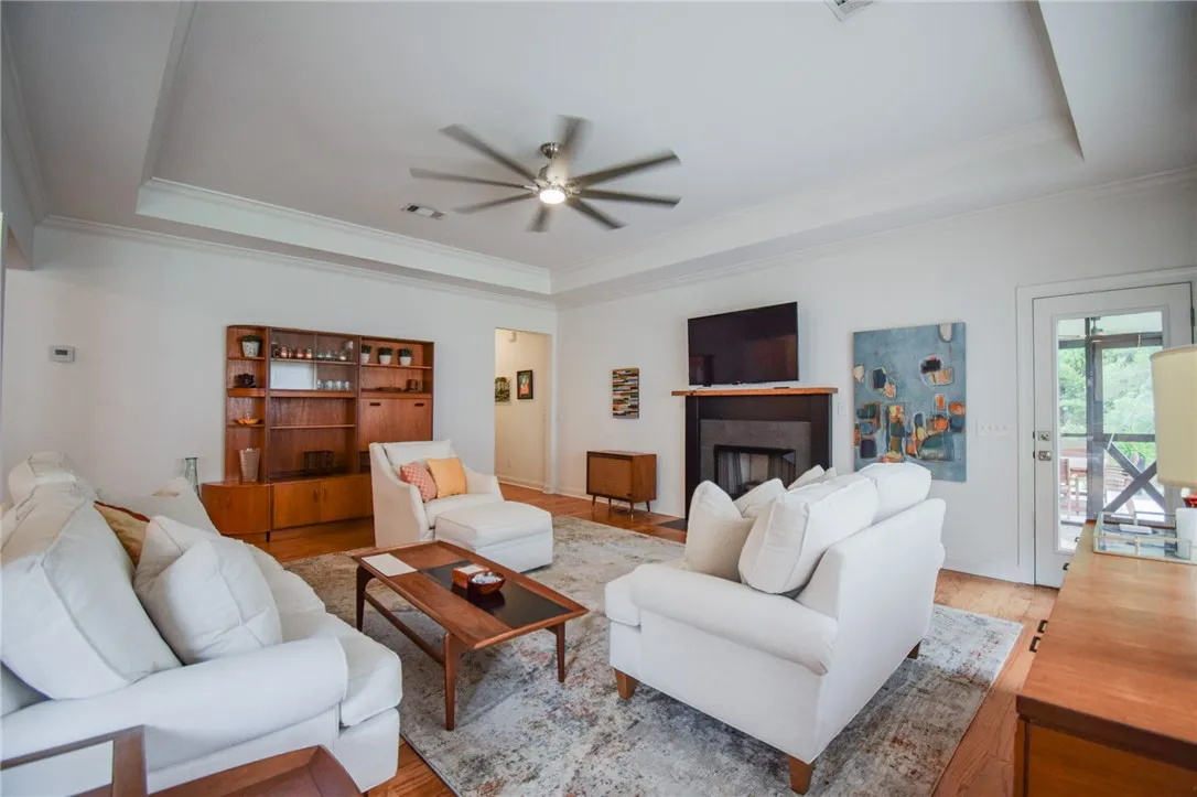 An elegant tray ceiling and rich hardwood floors anchor this inviting, open living space.