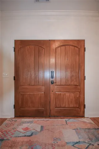 Double wood entry doors stand out against smooth walls accented by crisp crown molding.