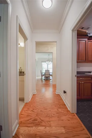 Gleaming hardwood floors and classic crown molding guide the way through this inviting central hallway.