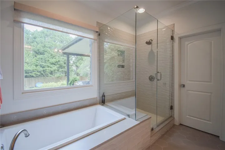 A spacious soaking tub and a glass-enclosed shower highlight this modern bathroom.