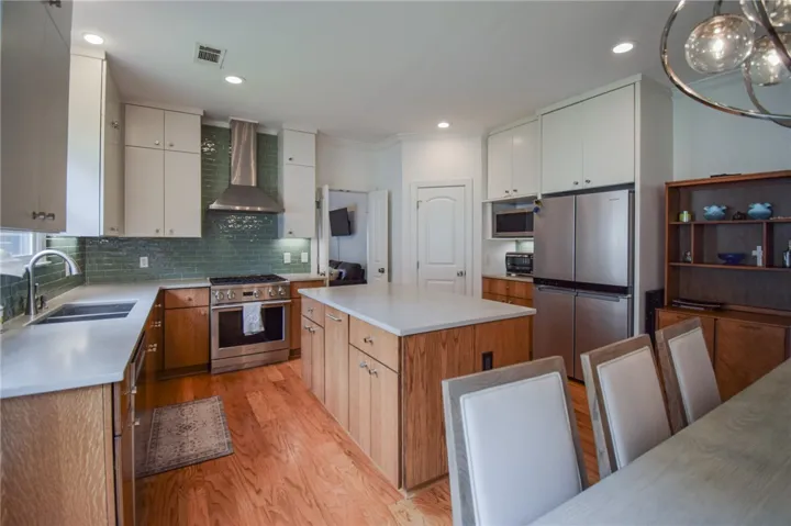 Gleaming hardwood floors and a spacious center island anchor this beautifully appointed modern kitchen.