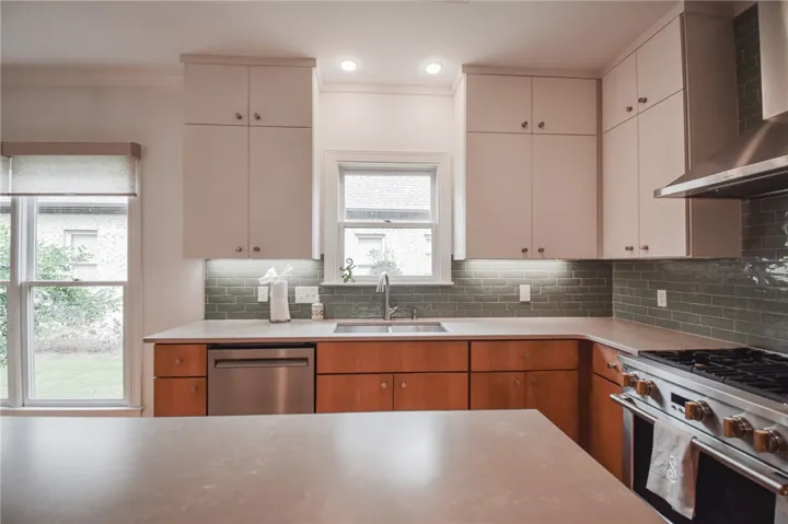 Streamlined cabinetry and classic tiled backsplashes anchor this thoughtfully designed cooking space.