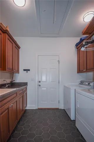 A functional workspace with built-in cabinetry and dark hexagonal tile flooring completes this room.