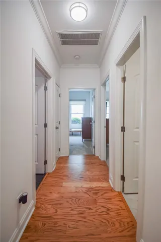 Gleaming hardwood floors guide you through a classic hallway accented by traditional crown molding.