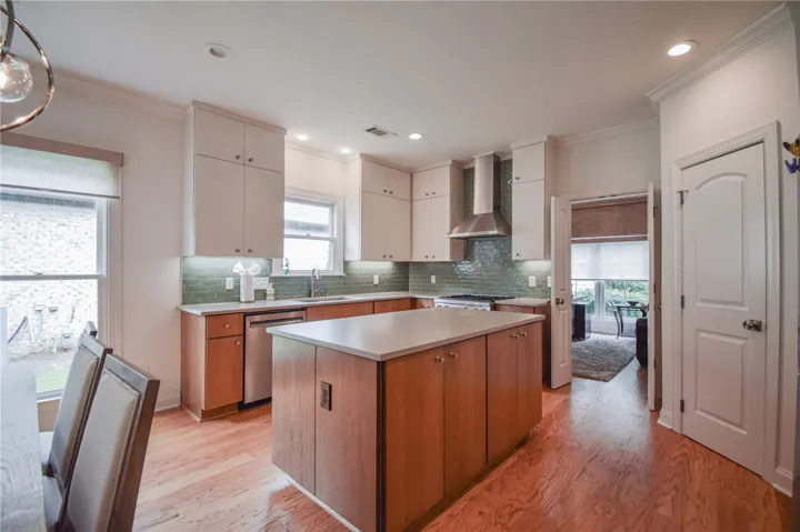 Gleaming hardwood floors and a spacious central island anchor this meticulously designed modern kitchen.