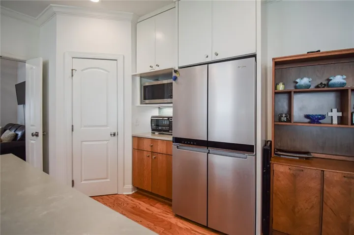 Gleaming hardwood floors and classic crown molding anchor this modern kitchen space.