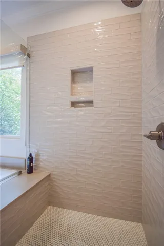 Glazed subway tiles line this shower, complete with built-in niches and penny floor tile.