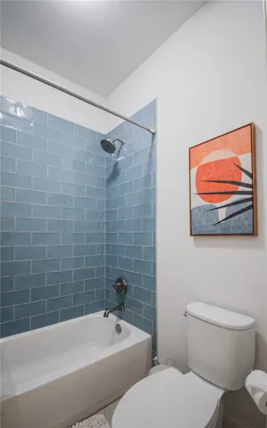 Glazed blue subway tile frames the clean-lined shower and bathtub combination.