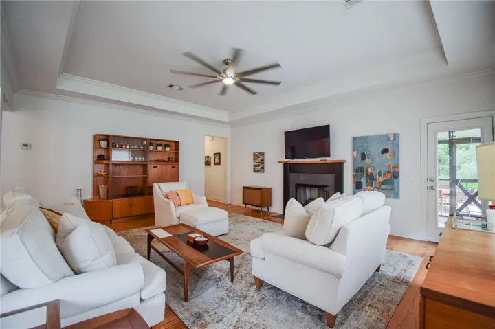 An elegant tray ceiling and rich hardwood floors anchor this inviting, open living space.