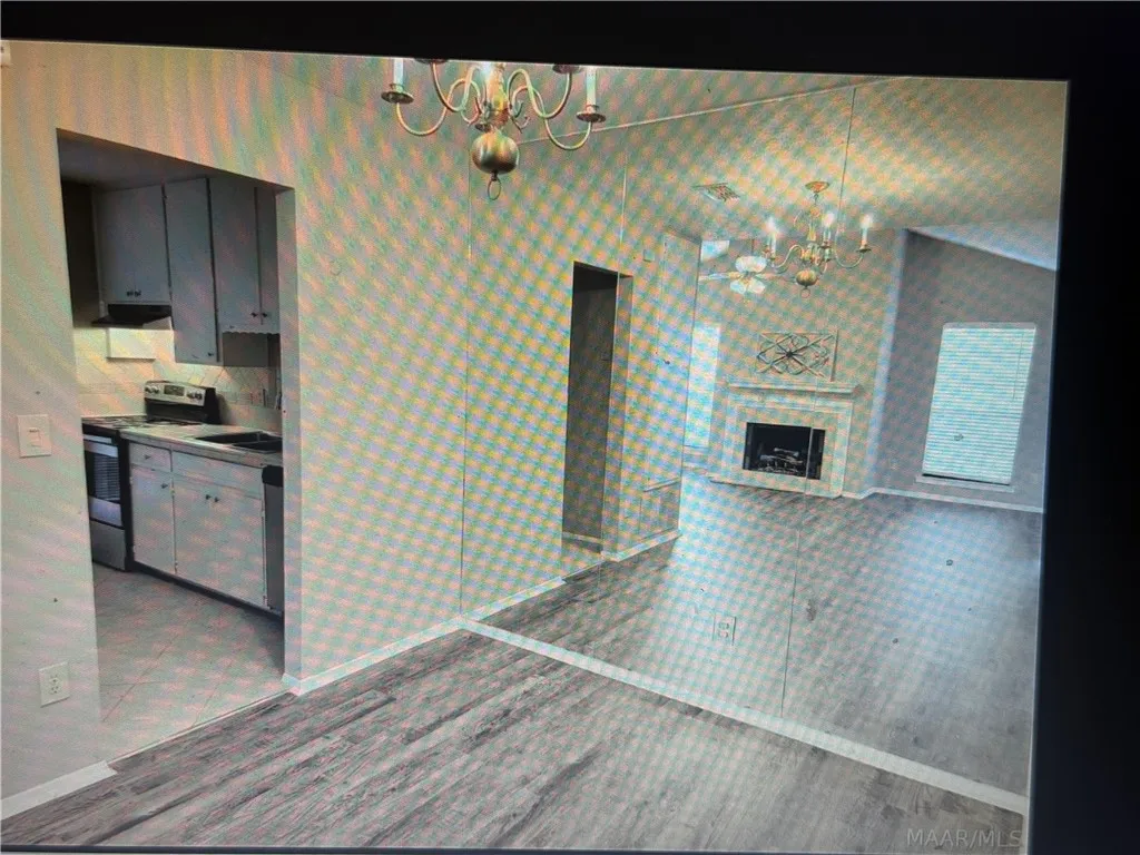 Laminated flooring runs through the dining area adjacent to the kitchen entryway.