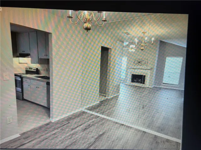 Laminated flooring runs through the dining area adjacent to the kitchen entryway.